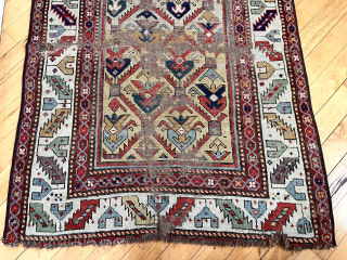 Early Caucasian long rug with a rich yellow ground and floral palmette lattice. Probably described as “gendge” for lack of a better name. Intact but with some heavy wear and exposed foundation.  ...