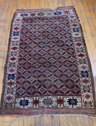 Antique Baluch rug. Unusual ivory border. Mostly good even low pile. Couple tiny holes. Original ends and sides. Clean. 3' 7" x 5' 9"         