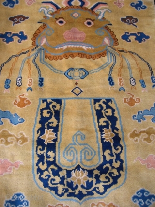 Chinese hanging/banner rug (3' 11" x 7' 4"); unusual t'ao-t'ieh mask design on pale gold field, full pile lustrous wool and in excellent condition; 20th century       