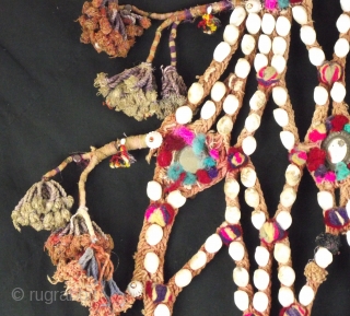Decorative rope camel trapping, this vintage piece is embellished with shells, mirrors and tassels with a large central fringed rope pom pom.
This would be worn by placing over the head and neck  ...