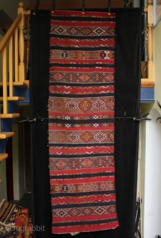 An old Anatolian long kilim runner, tightly woven flat weave with very fine çiçim and soumak embroidery, I estimate from the 1920s. Excellent drawing, good colours and in very good condition. 285x84cm

For  ...