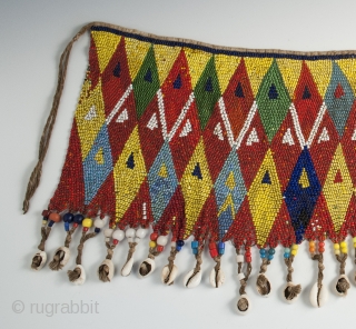 Pikuran (cache-sexe), Bana Guili people, Mandara Mountains, Cameroon. Seed beads, cotton string, cowrie shells, 19" (48.3 cm) wide by 9.5" (24 cm) high, mid 20th century or earlier.

The incredible variety of colored  ...