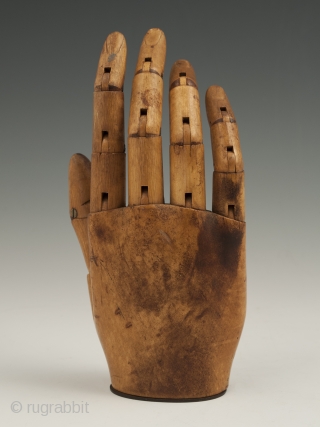 An expressive articulated carved wood mannequin hand, likely made in France. It measures 7" (17.7 cm) high by 3" (7.6 cm) wide. Late 19th to early 20th century.

     