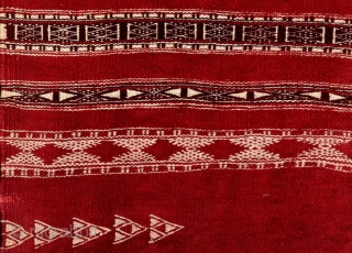 This wool baknough is from the village of Chenini, Tunisia. It has a glorious cochineal-colored field with intricate woven cream and black cotton designs. It has some damage on the fringe edges,  ...