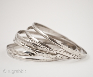 Schnesshin, seven silver bangles, Tunis, Tunisia. 8" (20.2 cm) interior circumference, Mid 20th century. Bangles are worn by Bedouin women in the city of Tunis in groups of seven, which is thought  ...