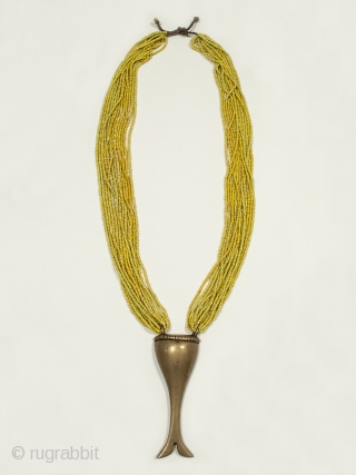 Necklace, Naga People, Nagaland, Northeastern India. Brass, glass trade beads, string. Early to mid 20th century. A graceful necklace of small yellow glass trade beads beads looped into a brass amulet. The  ...