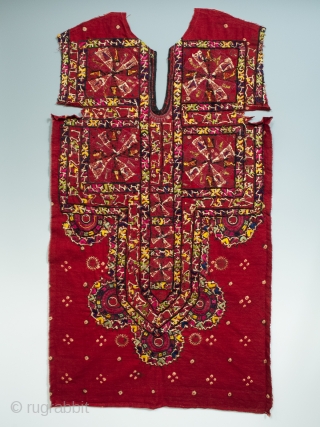 An embroidered shirt front from the Sindh region of Pakistan. Deep red cotton with some tie-dyed dots covered with silk thread embroidery and mirrored disks scattered throughout. In great condition with all  ...
